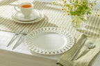 White Heirloom fine porcelain dinner plates set of 4 displayed elegantly on a dining table with tea and flowers.